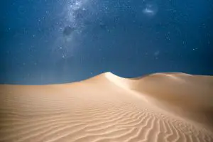 The milky way rising above moonlit dunes in Western Australia